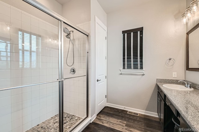 16546 Umatilla Pl, Broomfield, CO 80023 - full bath with a stall shower, wood finished floors, vanity, and baseboards