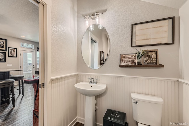 16546 Umatilla Pl, Broomfield, CO 80023 - bathroom with wood finished floors, wainscoting, toilet, and a sink