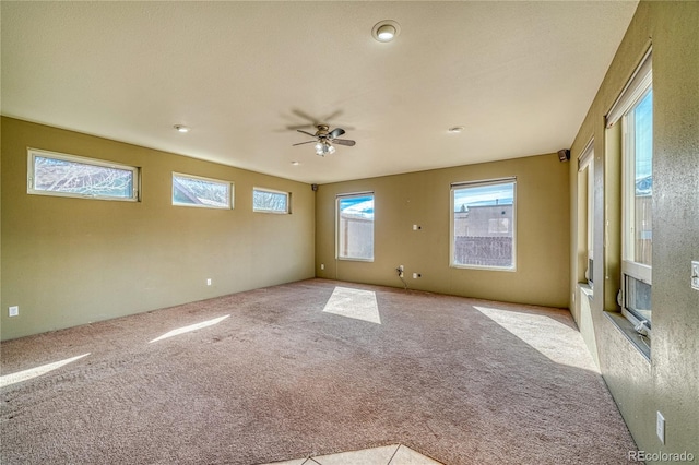 carpeted spare room featuring ceiling fan