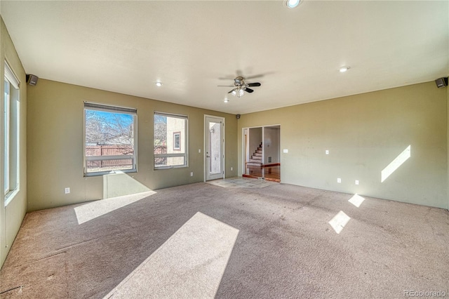 unfurnished living room featuring carpet flooring and ceiling fan