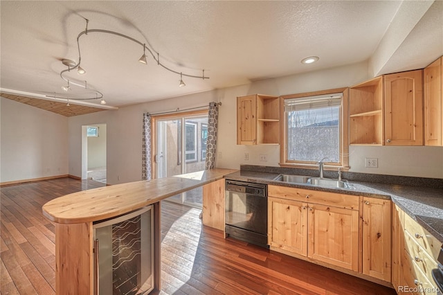 kitchen featuring black dishwasher, a sink, light brown cabinets, and open shelves