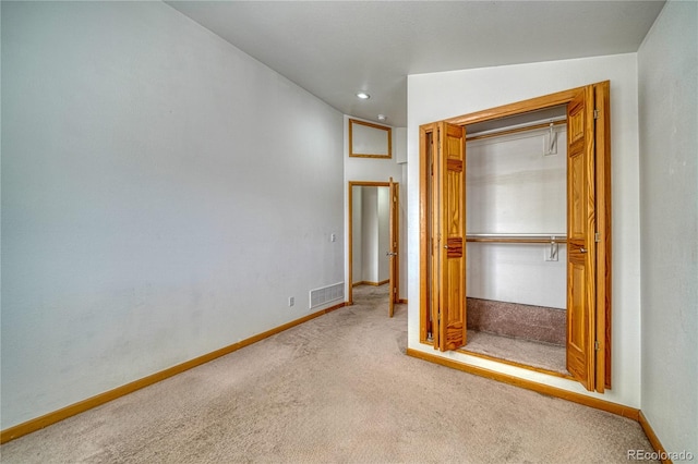 unfurnished bedroom featuring baseboards, visible vents, a closet, and carpet
