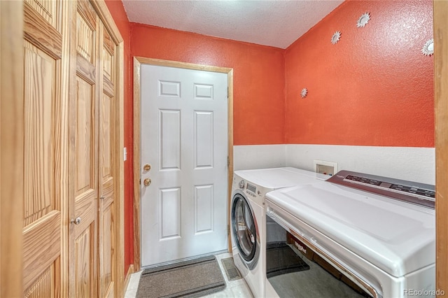laundry room featuring washing machine and dryer, laundry area, and a textured wall