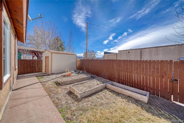 view of yard featuring a garden, a fenced backyard, an outbuilding, and a storage shed