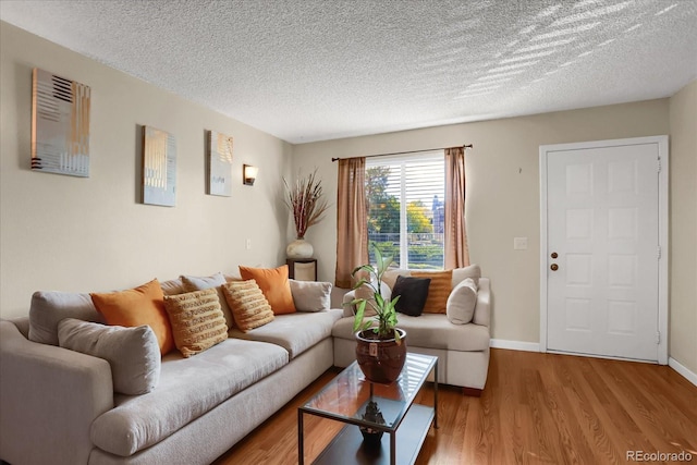 living room with light hardwood / wood-style flooring and a textured ceiling