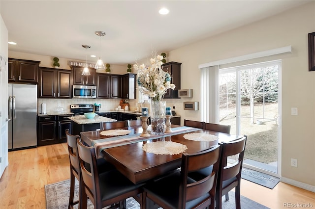 dining room with recessed lighting, baseboards, and light wood finished floors