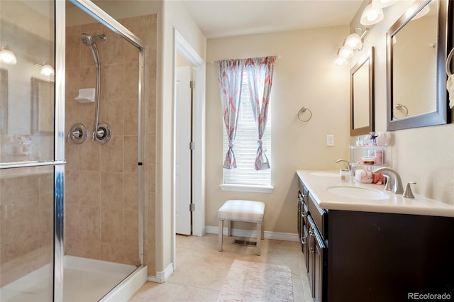 bathroom with a sink, double vanity, a shower stall, and tile patterned flooring