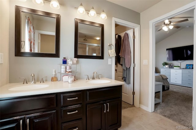 full bathroom featuring a sink, a ceiling fan, double vanity, and vaulted ceiling