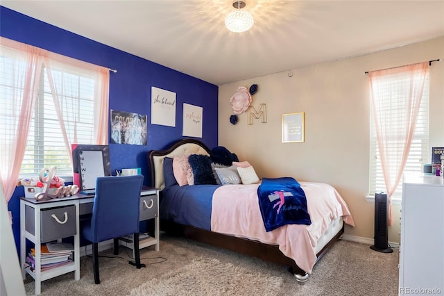 carpeted bedroom featuring multiple windows and baseboards