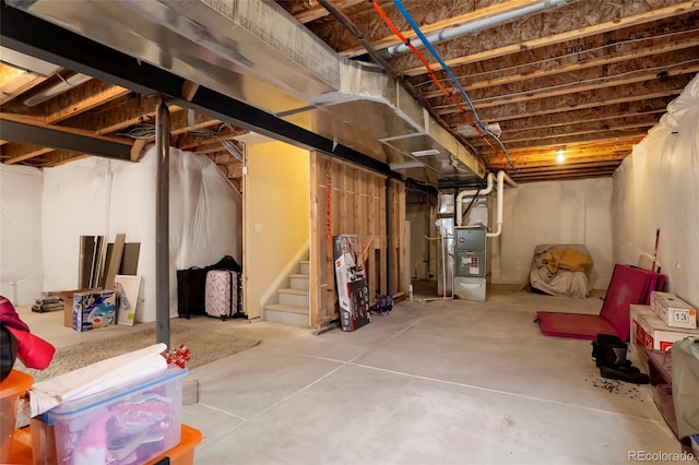 unfinished basement with stairs and heating unit