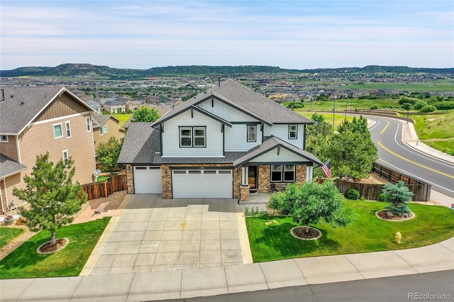 craftsman inspired home with a front lawn, a mountain view, and a garage