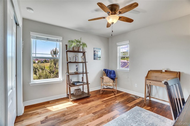 sitting room with ceiling fan and light wood-type flooring