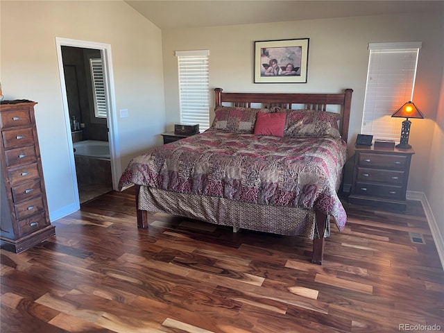 bedroom with dark hardwood / wood-style floors, ensuite bath, and vaulted ceiling