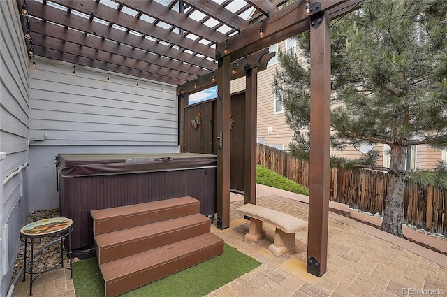 view of patio featuring a pergola, a hot tub, and fence