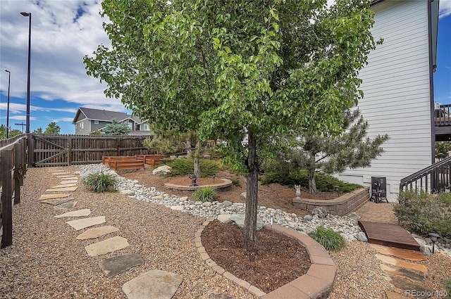 view of yard featuring a gate, a garden, and fence