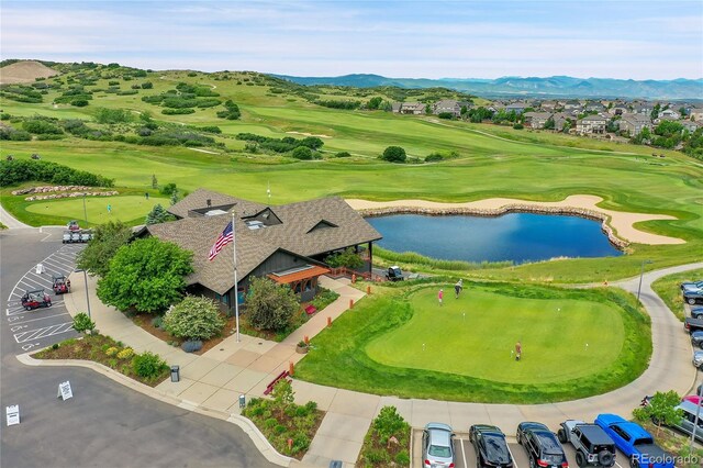 birds eye view of property with view of golf course and a water and mountain view