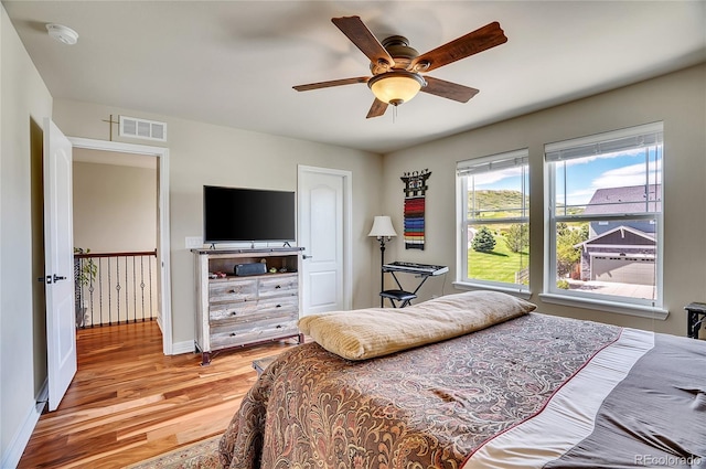 bedroom with visible vents, baseboards, a ceiling fan, and light wood finished floors