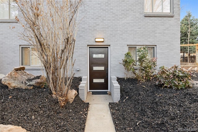 entrance to property featuring brick siding