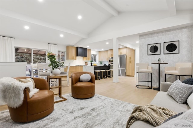 living area with light wood finished floors, a wealth of natural light, beam ceiling, and recessed lighting