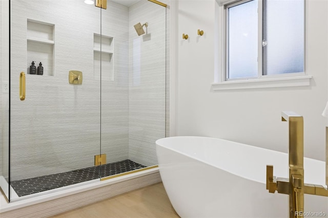 bathroom featuring a stall shower and a freestanding tub