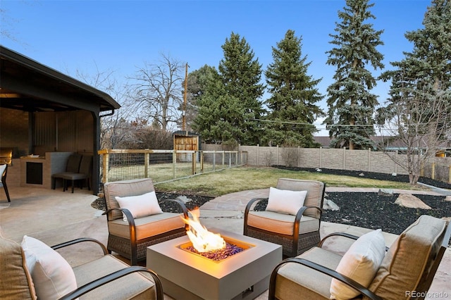 view of patio featuring a fenced backyard, grilling area, and an outdoor living space with a fire pit