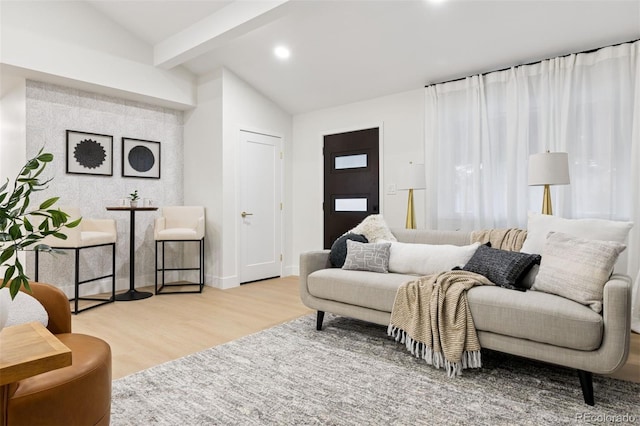 living area featuring lofted ceiling with beams, baseboards, wood finished floors, and recessed lighting