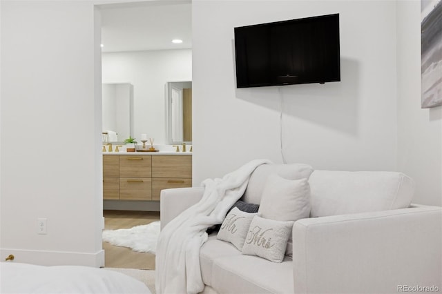 bedroom featuring light wood-style floors, recessed lighting, and connected bathroom