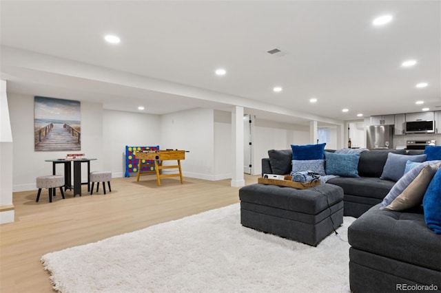 living area with baseboards, light wood-style flooring, and recessed lighting