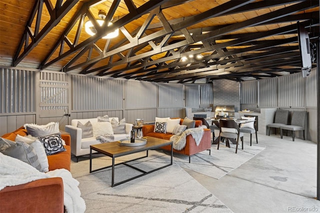 interior space with concrete floors, a garage, metal wall, and lofted ceiling