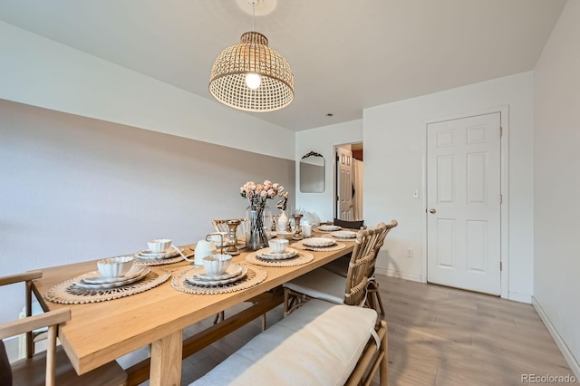 dining space featuring baseboards and light wood finished floors
