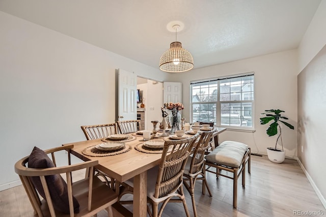 dining room featuring baseboards and light wood-type flooring