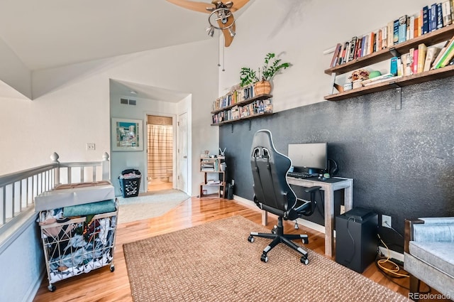 home office with visible vents, baseboards, lofted ceiling, and wood finished floors