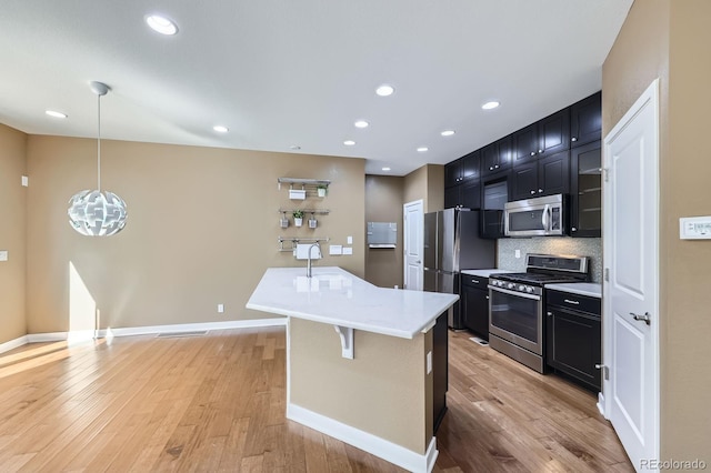 11323 Uptown Ave, Broomfield, CO 80021 - kitchen featuring backsplash, stainless steel appliances, light countertops, and dark cabinetry