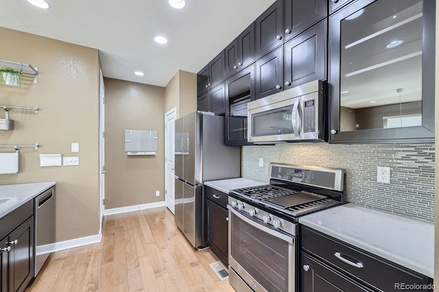 11323 Uptown Ave, Broomfield, CO 80021 - kitchen featuring light stone counters, light wood-type flooring, baseboards, tasteful backsplash, and appliances with stainless steel finishes