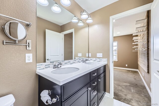 11323 Uptown Ave, Broomfield, CO 80021 - full bath with double vanity, toilet, baseboards, and a sink