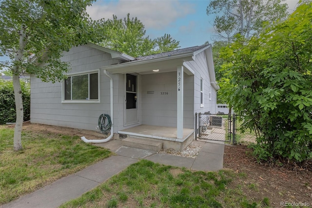 3256 S Ogden St, Englewood, CO 80113 - view of front facade featuring a gate, a front lawn, and a shingled roof