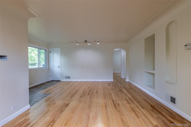 3256 S Ogden St, Englewood, CO 80113 - spare room with arched walkways, built in shelves, track lighting, light wood-style flooring, and baseboards