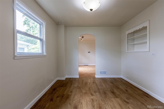 3256 S Ogden St, Englewood, CO 80113 - unfurnished room featuring arched walkways, wood finished floors, and baseboards