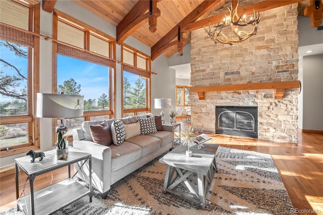 living area with wood finished floors, wooden ceiling, beam ceiling, a fireplace, and a notable chandelier