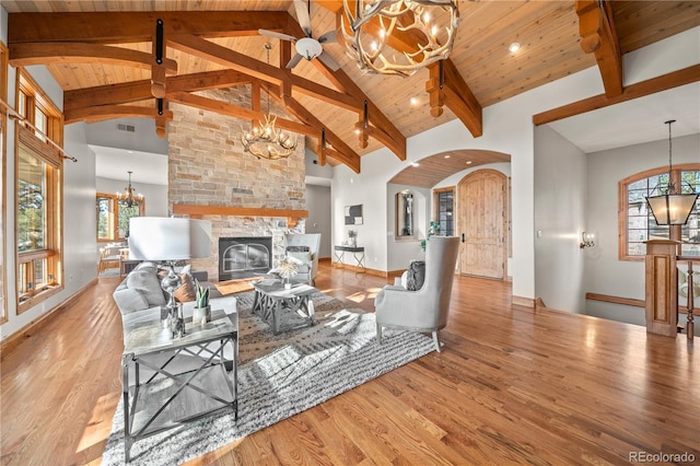 living area featuring arched walkways, wood finished floors, an inviting chandelier, and a wealth of natural light