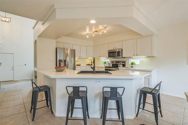 4807 Fenwood Dr, Highlands Ranch, CO 80130 - kitchen with appliances with stainless steel finishes, a breakfast bar area, light tile patterned flooring, and white cabinets
