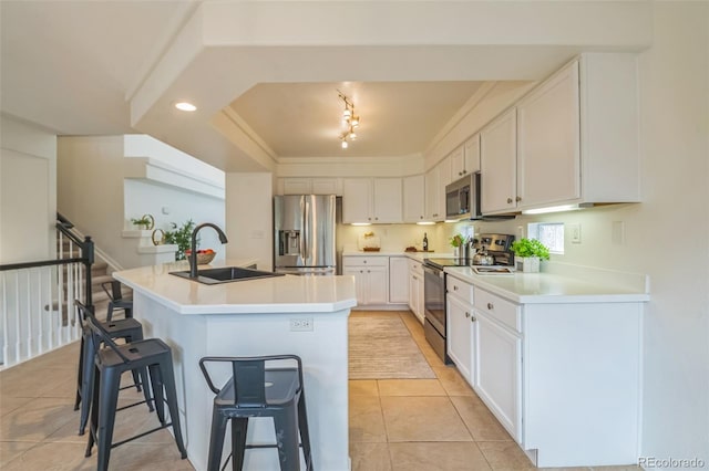 4807 Fenwood Dr, Highlands Ranch, CO 80130 - kitchen featuring appliances with stainless steel finishes, a breakfast bar area, white cabinets, an island with sink, and light tile patterned floors