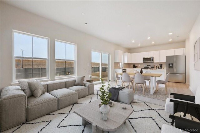 living area featuring light wood finished floors and recessed lighting