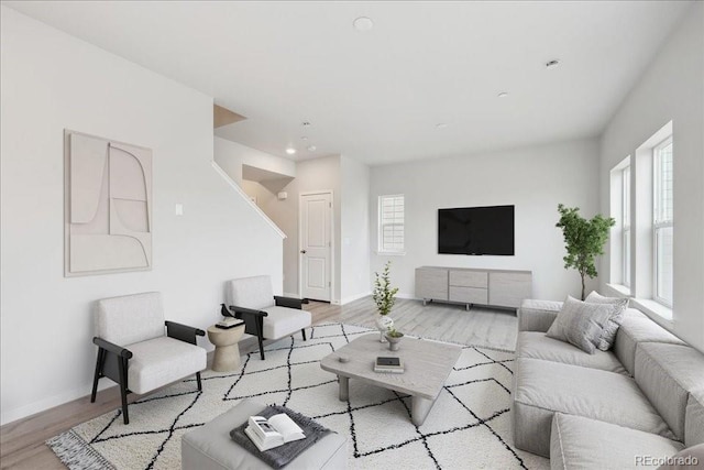 living area with baseboards, recessed lighting, and wood finished floors