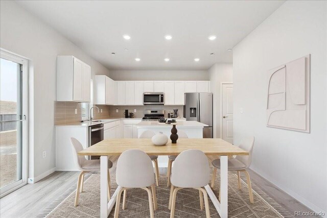 kitchen featuring a sink, light wood finished floors, stainless steel appliances, and light countertops