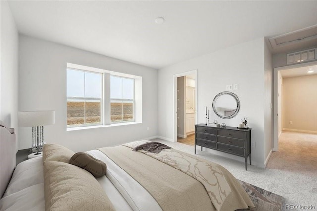 carpeted bedroom with ensuite bathroom, baseboards, and visible vents