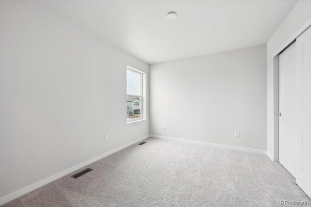 unfurnished bedroom with baseboards, carpet flooring, and visible vents