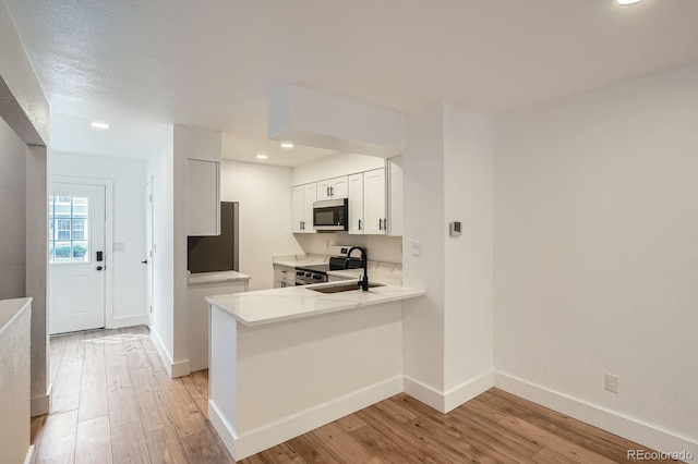 8197 S Fillmore Way, Centennial, CO 80122 - kitchen featuring stainless steel appliances, light wood-style floors, recessed lighting, white cabinetry, and a peninsula