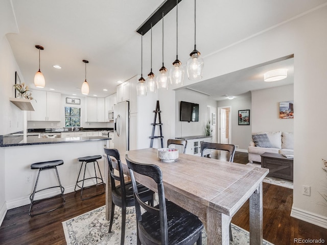 dining room with dark wood-type flooring, recessed lighting, and baseboards