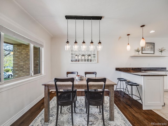 dining area featuring baseboards and dark wood-style floors